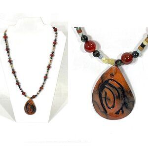 Polished carnelian and other stone necklace with signed carved pendant.